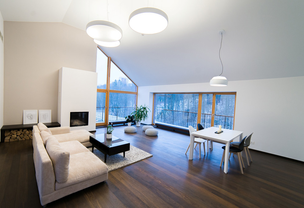 Cette image montre un grand salon design ouvert avec une salle de réception, un mur blanc, parquet foncé et une cheminée standard.