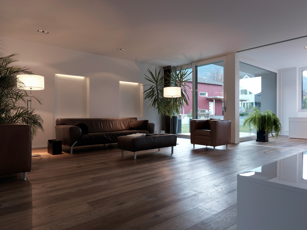 Imagen de salón actual grande con suelo de madera clara