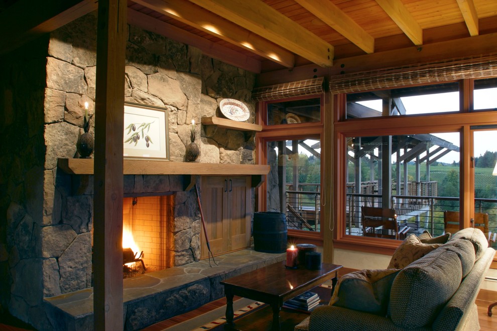 Example of a mid-sized minimalist open concept dark wood floor and brown floor living room design in Portland with beige walls, a wood stove, a stone fireplace and no tv
