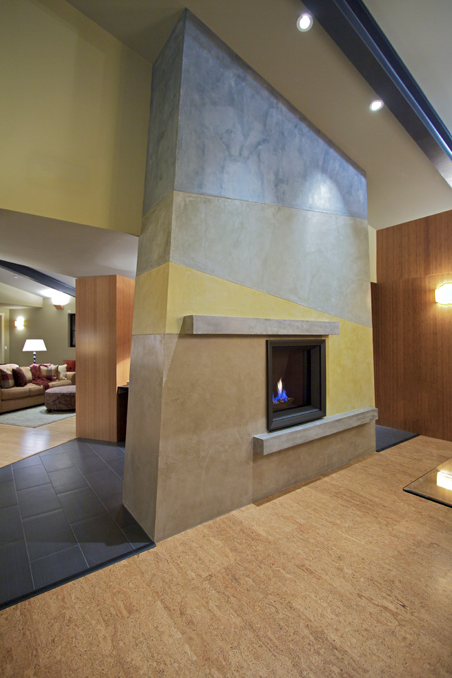 Cette photo montre un grand salon tendance ouvert avec une salle de réception, un mur multicolore, sol en stratifié, une cheminée double-face, un manteau de cheminée en pierre, aucun téléviseur et un sol beige.