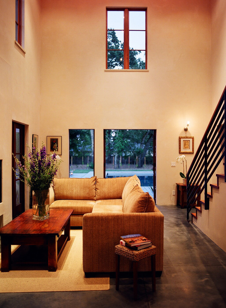 Esempio di un soggiorno design di medie dimensioni e aperto con pavimento in cemento e pareti beige