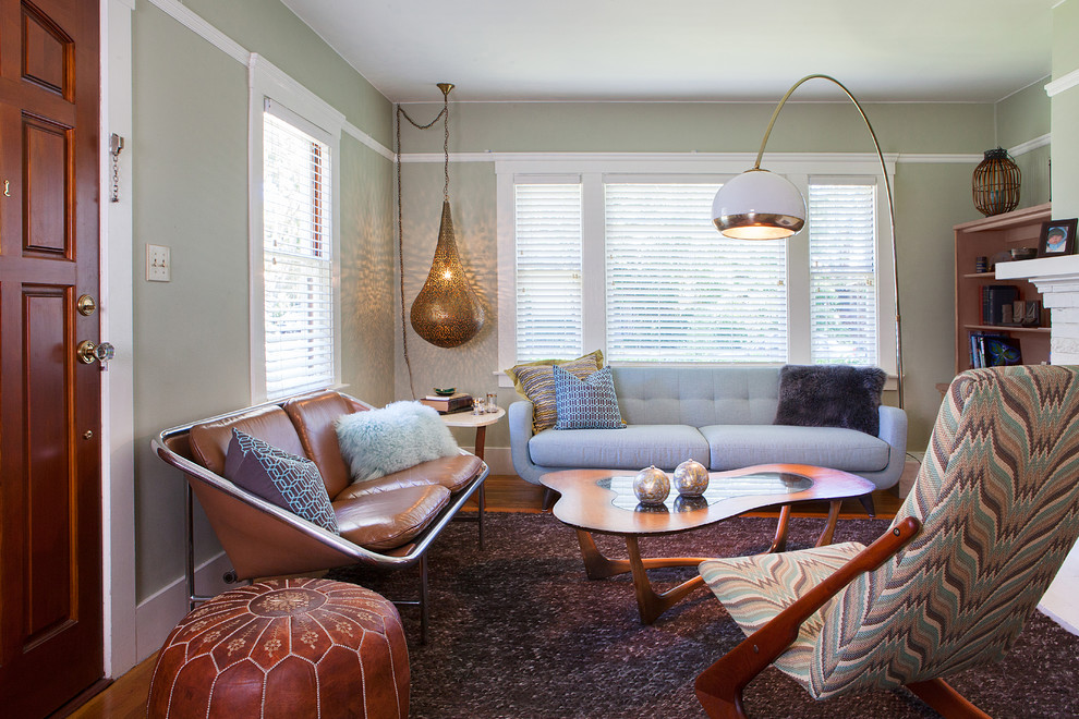 Diseño de salón para visitas abierto retro pequeño sin chimenea y televisor con paredes verdes, suelo de madera en tonos medios y alfombra