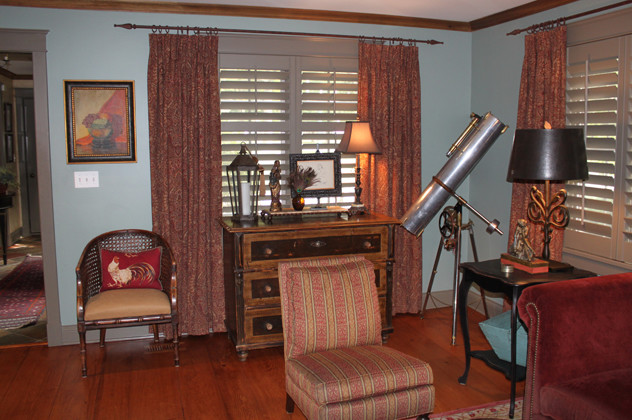 Cette photo montre un salon montagne de taille moyenne et fermé avec une salle de réception, un mur bleu, un sol en bois brun, une cheminée standard, un manteau de cheminée en bois et aucun téléviseur.