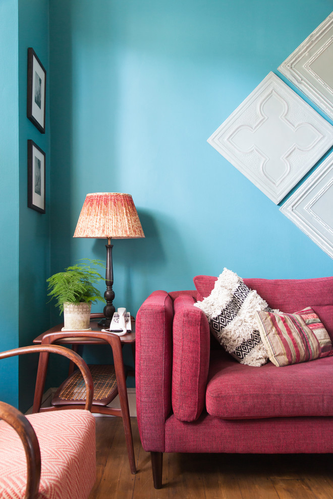 Diseño de salón abierto bohemio pequeño con paredes azules y suelo de madera en tonos medios