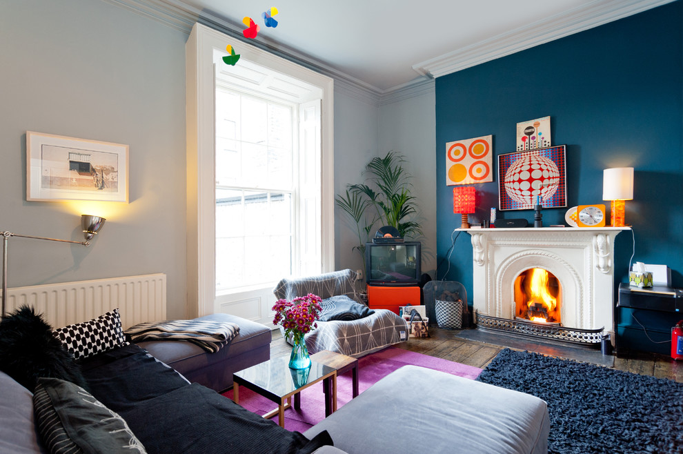Living room - mid-sized eclectic enclosed dark wood floor and brown floor living room idea in Dublin with multicolored walls, a standard fireplace, a metal fireplace and a tv stand