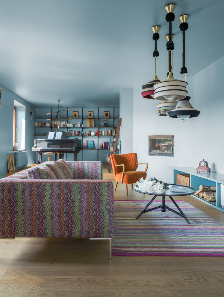 Großes, Offenes Stilmix Wohnzimmer mit blauer Wandfarbe, hellem Holzboden, beigem Boden, Eckkamin, verputzter Kaminumrandung und TV-Wand in London