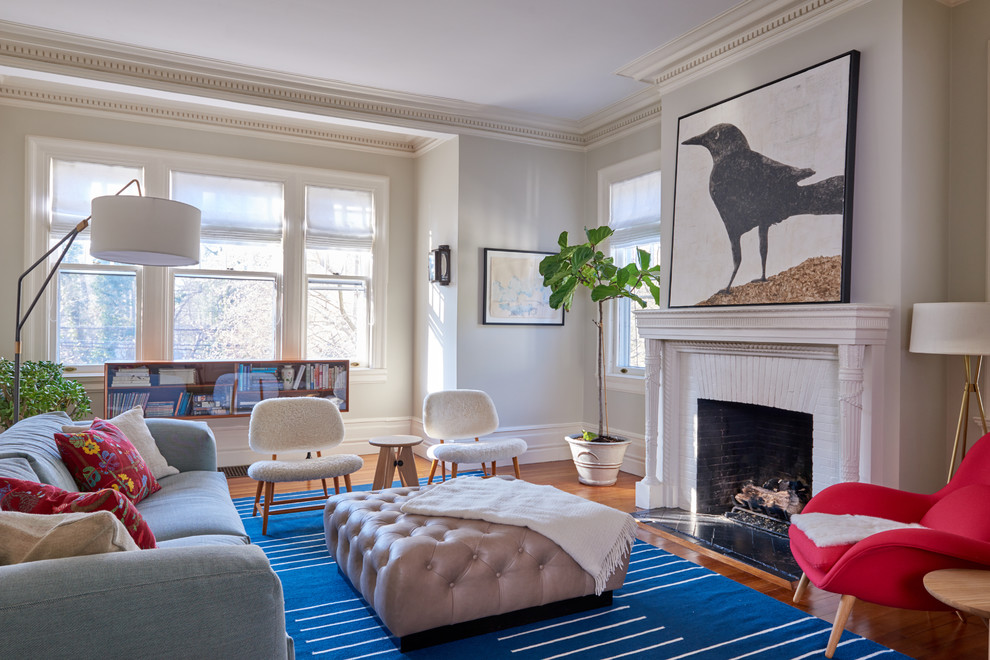 Klassisches Wohnzimmer mit grauer Wandfarbe, braunem Holzboden, Kamin, Kaminumrandung aus Backstein und braunem Boden in New York