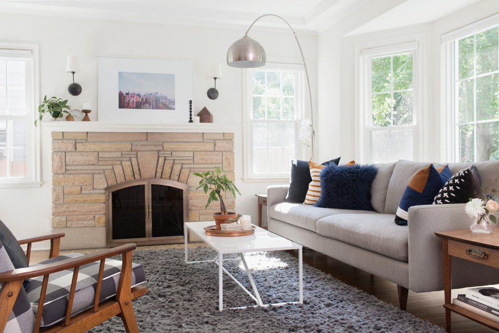 Design ideas for a medium sized eclectic open plan living room in Minneapolis with white walls, medium hardwood flooring, a standard fireplace, a brick fireplace surround, a wall mounted tv and brown floors.