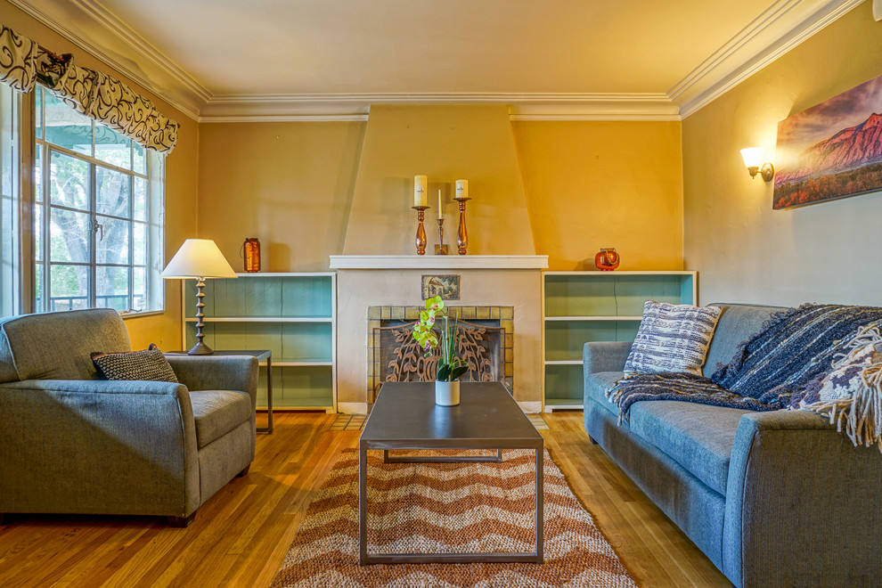 Diseño de salón para visitas cerrado de estilo americano pequeño con paredes beige, suelo de madera clara, todas las chimeneas y marco de chimenea de yeso