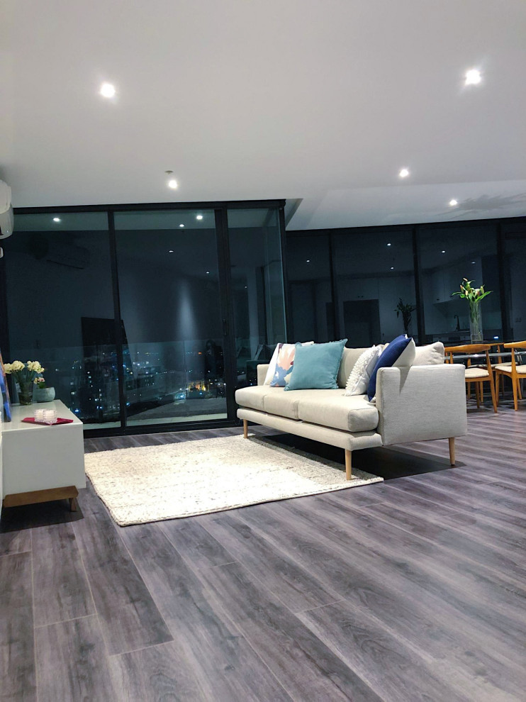 This is an example of a small modern open plan living room in Melbourne with laminate floors and grey floors.