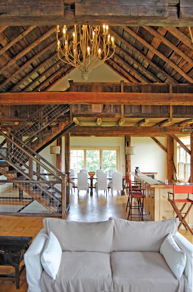 Diseño de salón abierto de estilo de casa de campo con suelo de madera clara