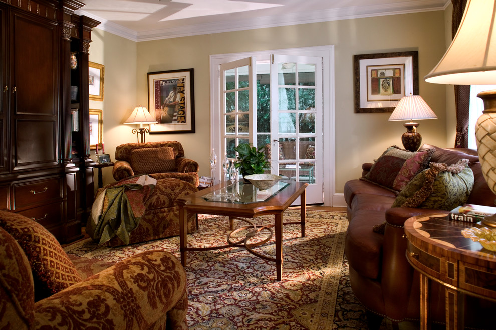 Ejemplo de salón abierto clásico de tamaño medio con paredes verdes, suelo de madera en tonos medios, televisor retractable y suelo beige