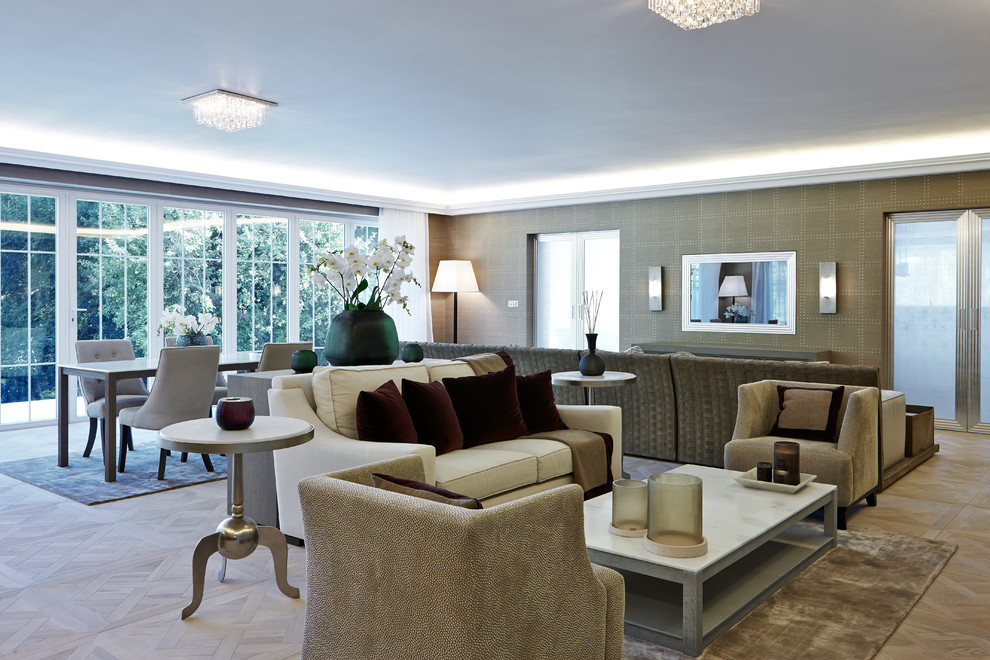 Стильный дизайн: большая парадная, открытая гостиная комната в стиле неоклассика (современная классика) с бежевыми стенами, светлым паркетным полом и телевизором на стене - последний тренд