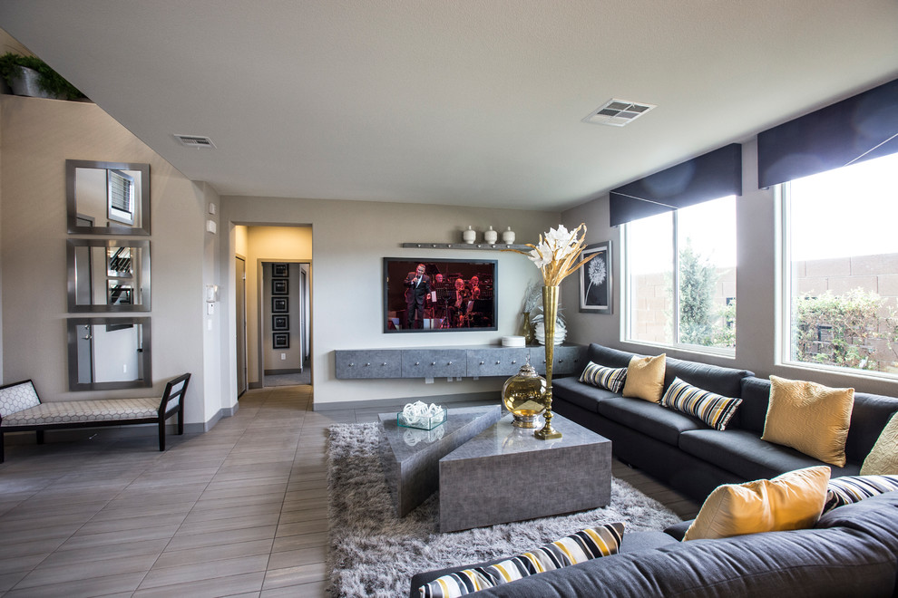 Modelo de salón abierto actual de tamaño medio con paredes beige, suelo de madera en tonos medios y televisor colgado en la pared