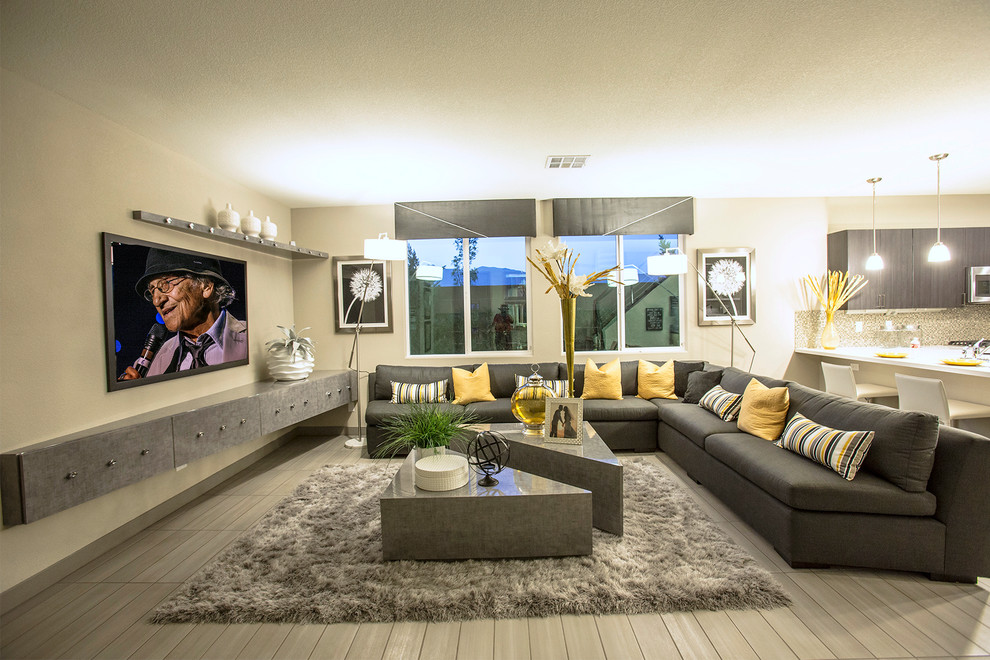 Ejemplo de salón abierto contemporáneo de tamaño medio con paredes beige, suelo de madera en tonos medios y televisor colgado en la pared