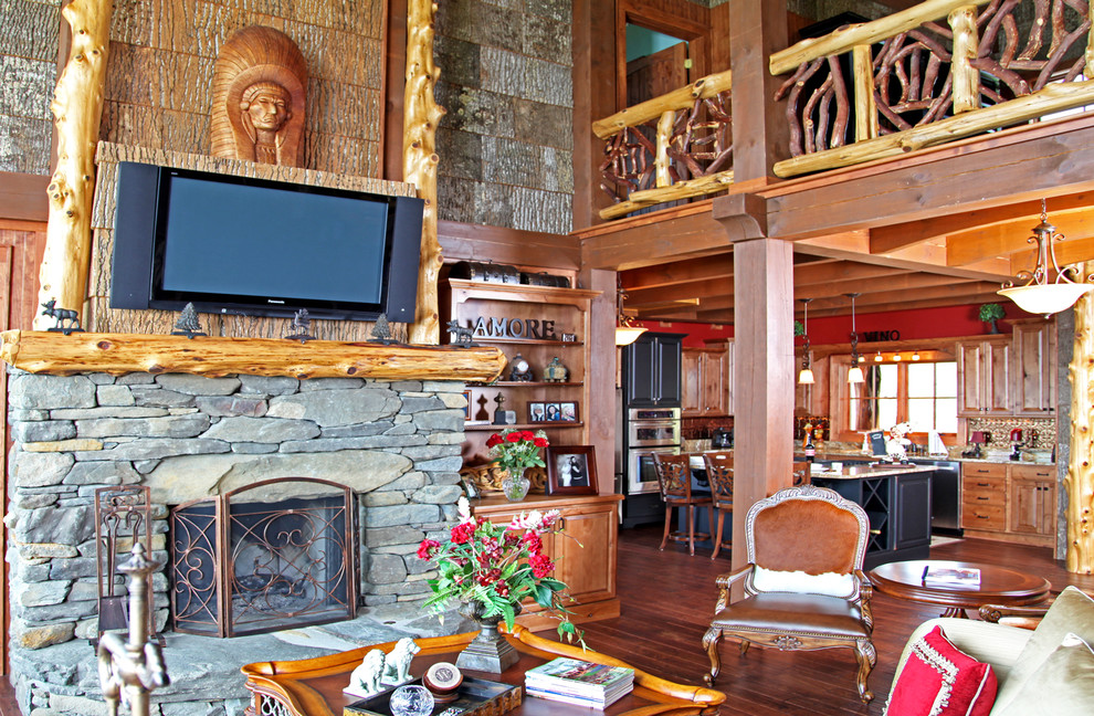 Imagen de salón para visitas abierto rústico grande con paredes marrones, suelo de madera en tonos medios, todas las chimeneas, marco de chimenea de piedra y televisor colgado en la pared
