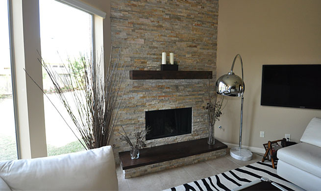 Diseño de salón minimalista de tamaño medio con paredes beige, suelo de baldosas de cerámica, chimenea de esquina y marco de chimenea de piedra