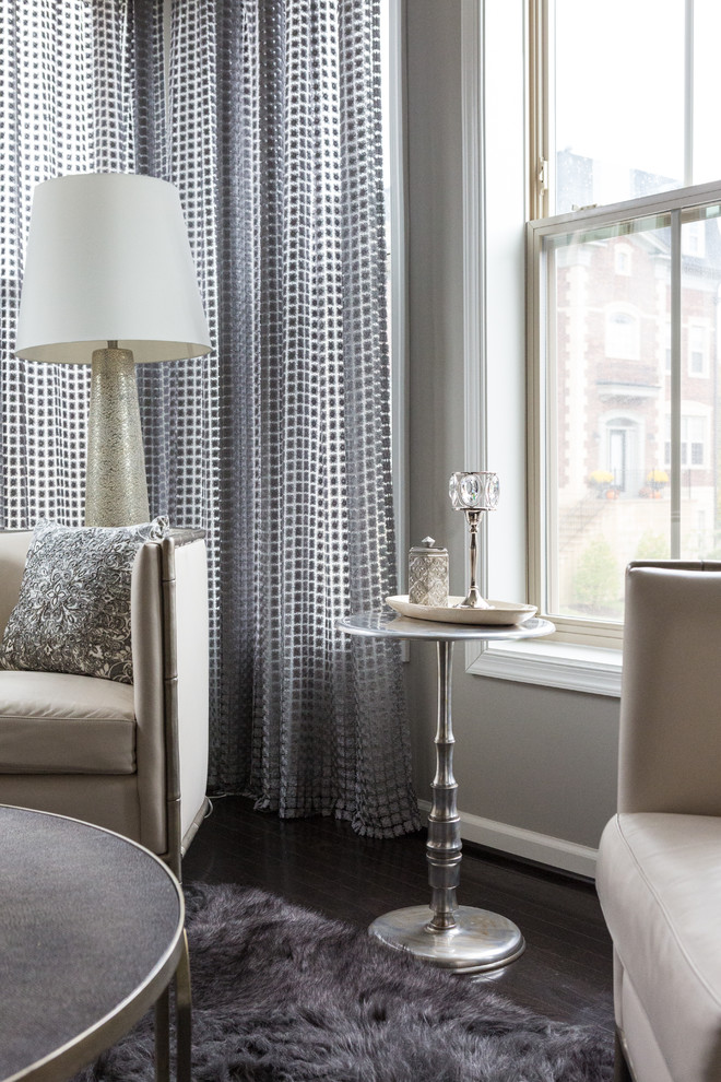 Idée de décoration pour un salon tradition avec un mur gris et parquet foncé.