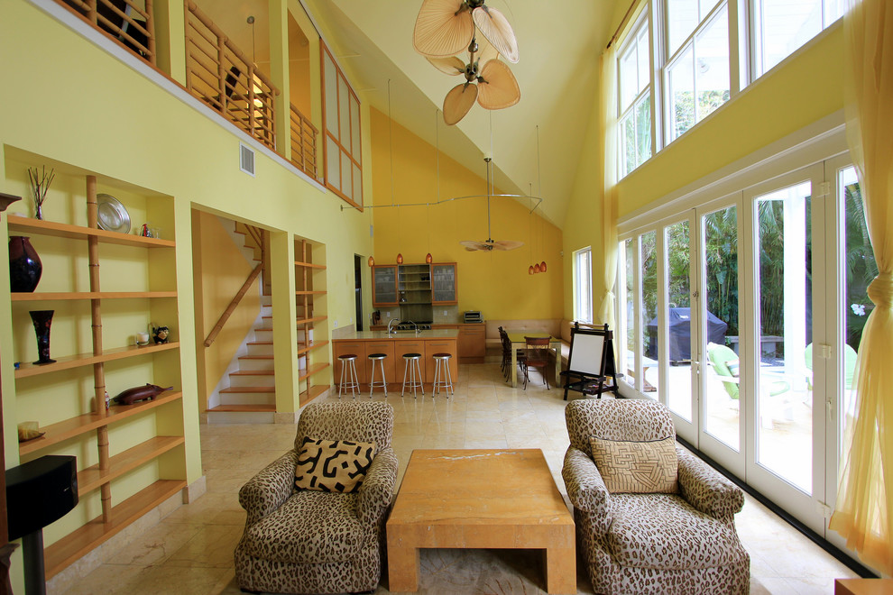 Modelo de salón tipo loft contemporáneo de tamaño medio con paredes amarillas y suelo de travertino