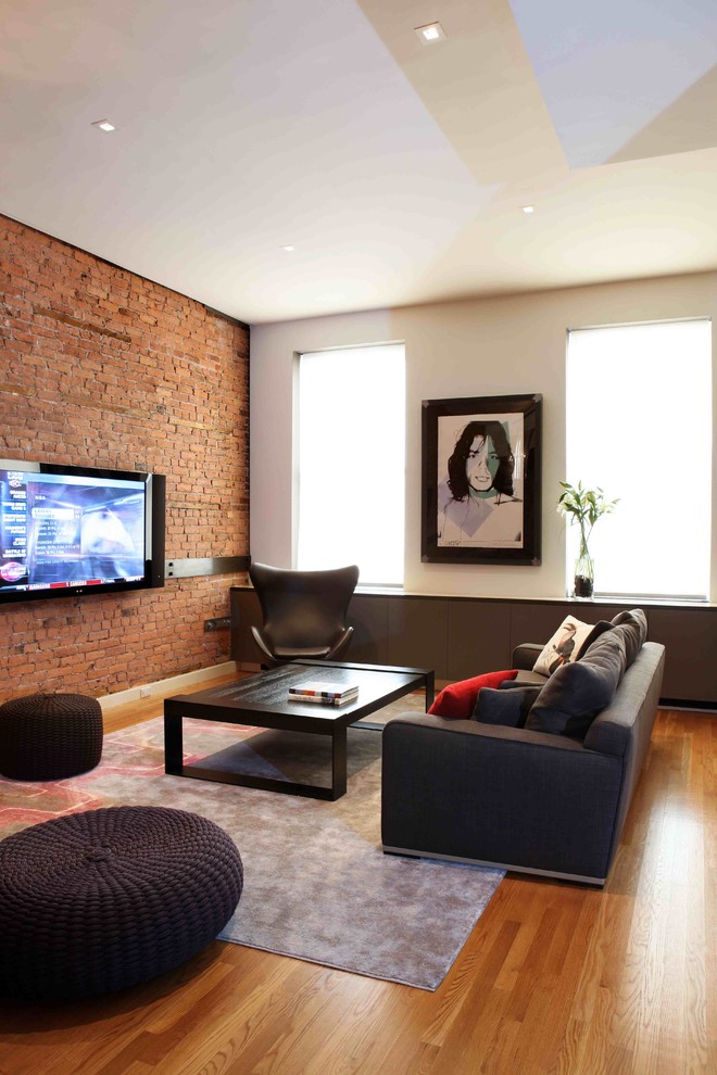 Modernes Wohnzimmer mit braunem Holzboden und TV-Wand in New York