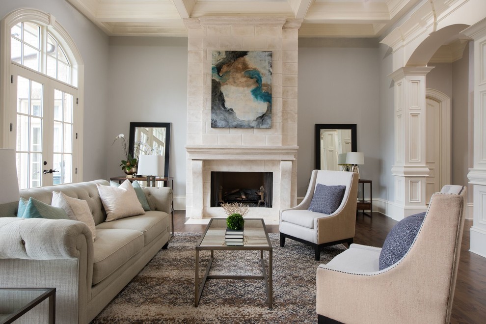 Foto di un soggiorno chic con sala formale, pareti grigie, pavimento in legno massello medio, camino classico e pavimento marrone