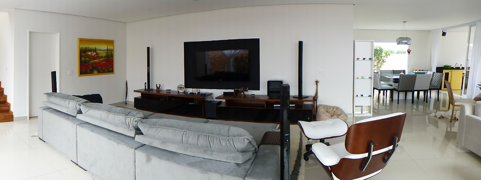 Aménagement d'un grand salon contemporain ouvert avec une salle de réception, un mur blanc, un sol en carrelage de porcelaine et un téléviseur encastré.