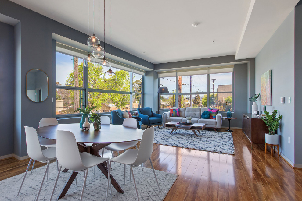 Immagine di un grande soggiorno minimalista stile loft con pareti grigie, pavimento in laminato e pavimento marrone