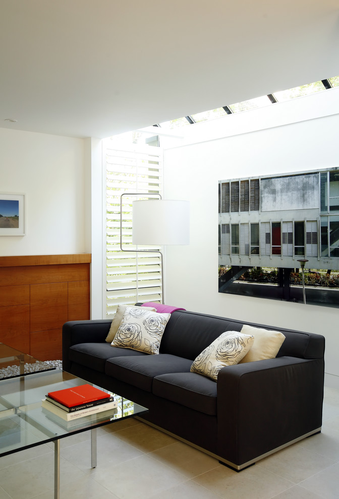 Cette image montre un salon minimaliste de taille moyenne et ouvert avec un mur blanc, un sol en calcaire, une cheminée standard, un manteau de cheminée en bois et canapé noir.