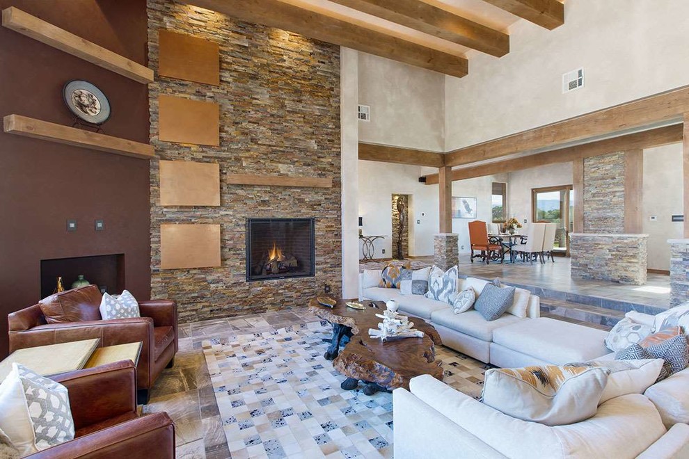 Großes, Fernseherloses, Offenes Mediterranes Wohnzimmer mit beiger Wandfarbe, Kamin, Kaminumrandung aus Stein und Keramikboden in Albuquerque