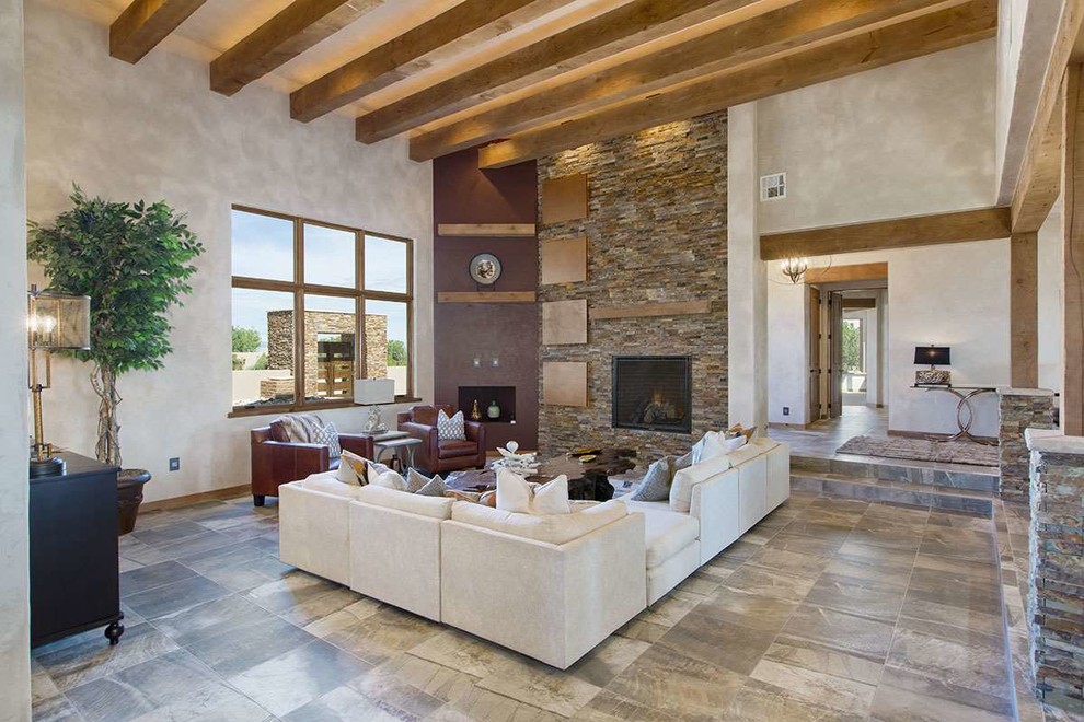 Inspiration for a large southwestern open concept ceramic tile living room remodel in Albuquerque with beige walls, a standard fireplace and a stone fireplace