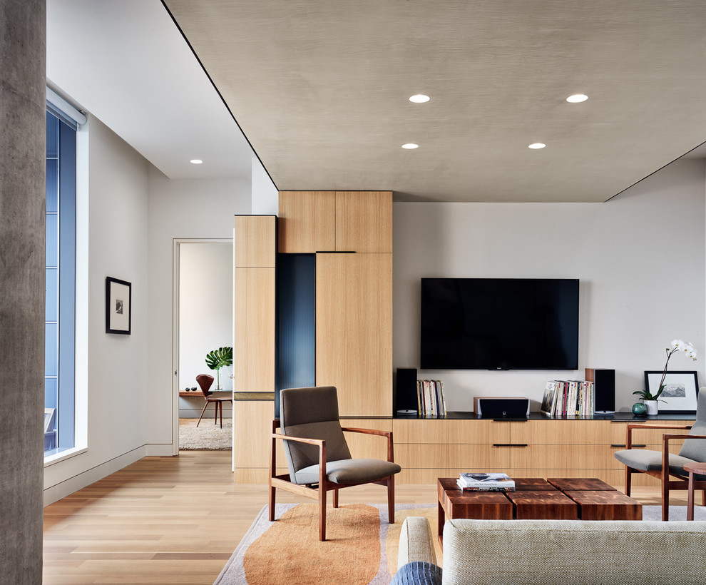 Стильный дизайн: парадная, открытая гостиная комната в современном стиле с серыми стенами, светлым паркетным полом, телевизором на стене и бежевым полом - последний тренд