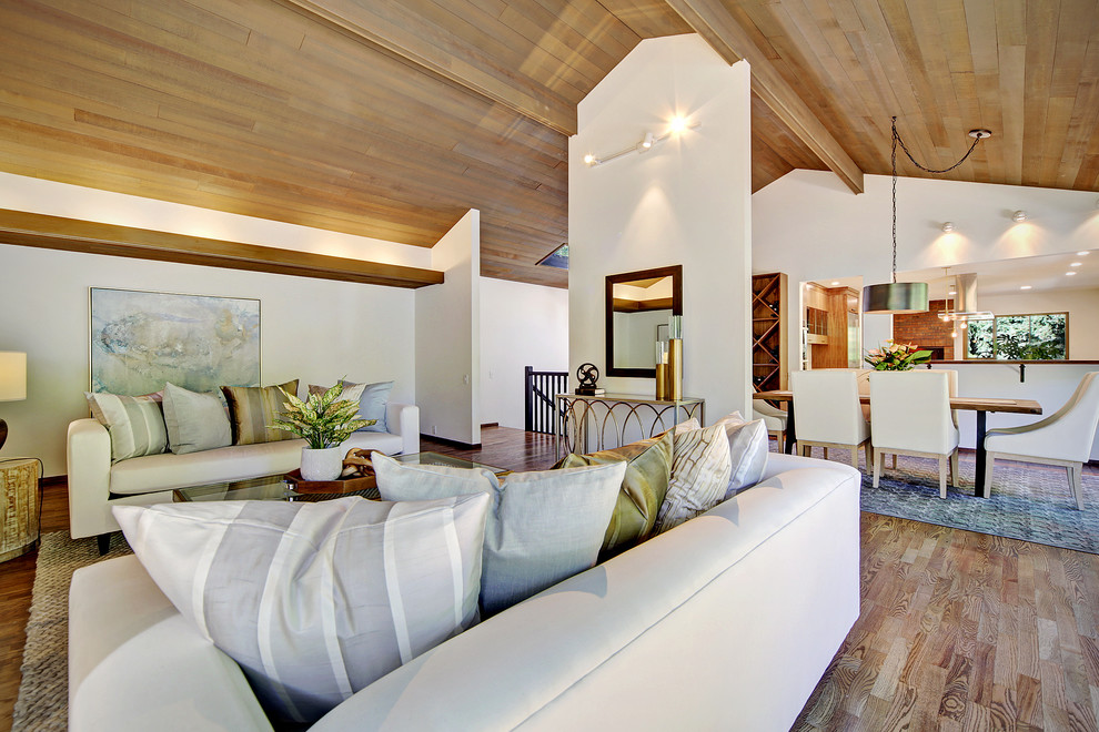 Diseño de salón abierto vintage grande con paredes blancas, suelo de madera en tonos medios y suelo marrón
