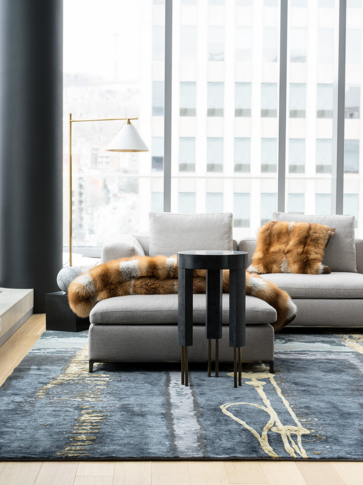 Immagine di un grande soggiorno design aperto con parquet chiaro