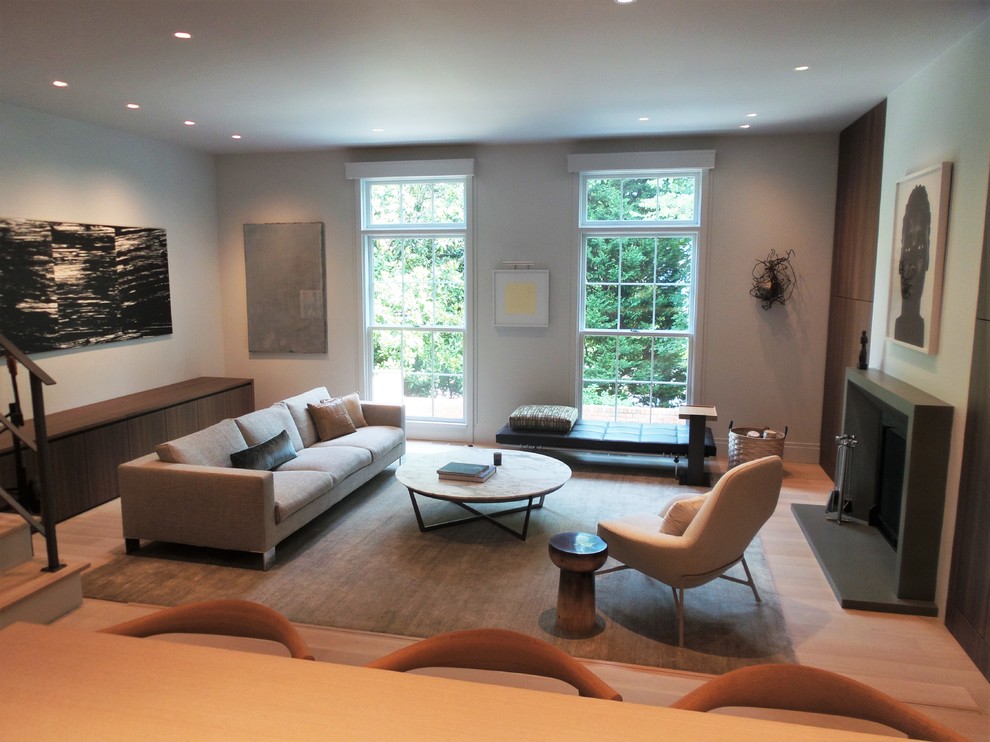 Geräumiges, Offenes Modernes Wohnzimmer mit weißer Wandfarbe, hellem Holzboden, Kamin und Kaminumrandung aus Beton in Atlanta