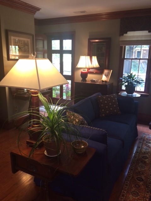 Inspiration for a medium sized traditional open plan living room in Raleigh with green walls, light hardwood flooring, a standard fireplace, a brick fireplace surround and no tv.
