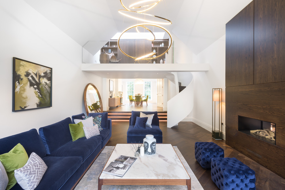 Offenes Modernes Wohnzimmer mit weißer Wandfarbe, dunklem Holzboden, Gaskamin, Kaminumrandung aus Holz und braunem Boden in London