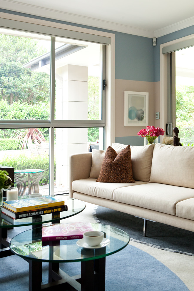 На фото: открытая гостиная комната среднего размера в современном стиле с синими стенами, телевизором на стене и белым полом без камина с