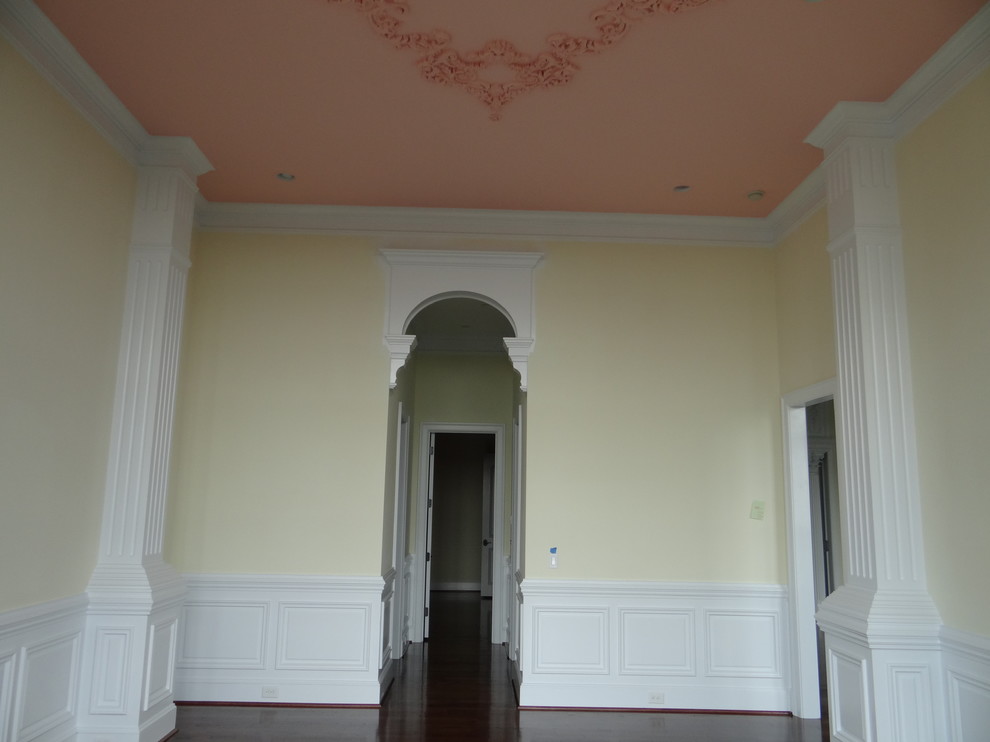 Ejemplo de salón clásico con paredes amarillas y suelo de madera oscura