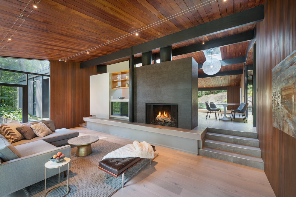 Inspiration for a mid-sized 1950s open concept light wood floor and beige floor living room remodel in Boston with brown walls, a standard fireplace, a tile fireplace and a wall-mounted tv