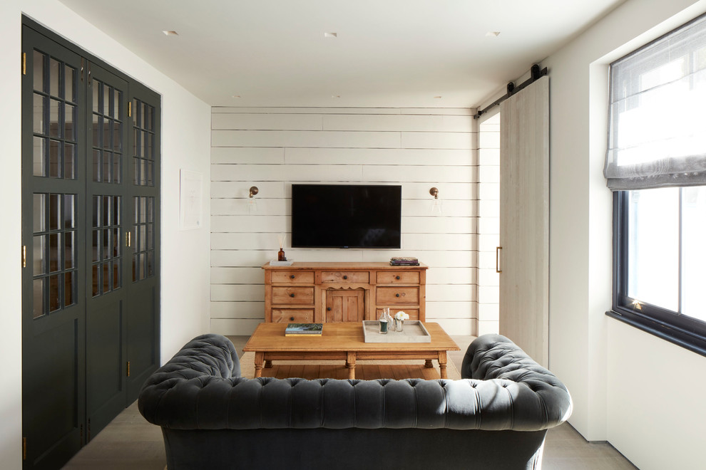 Mittelgroßes, Abgetrenntes Modernes Wohnzimmer mit weißer Wandfarbe, TV-Wand und grauem Boden in London