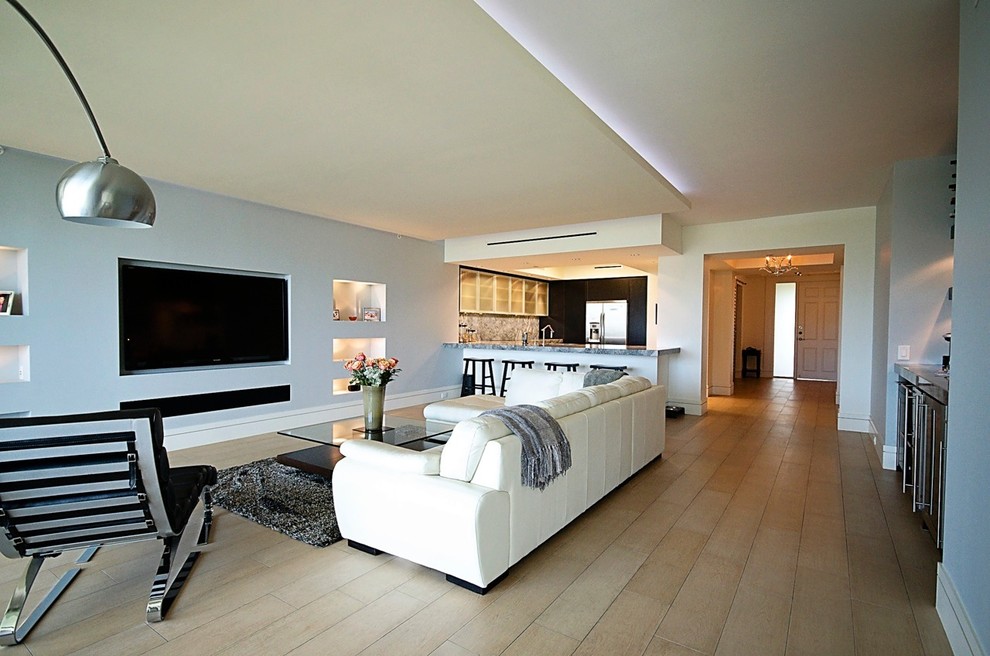 Пример оригинального дизайна: открытая гостиная комната в стиле модернизм с телевизором на стене