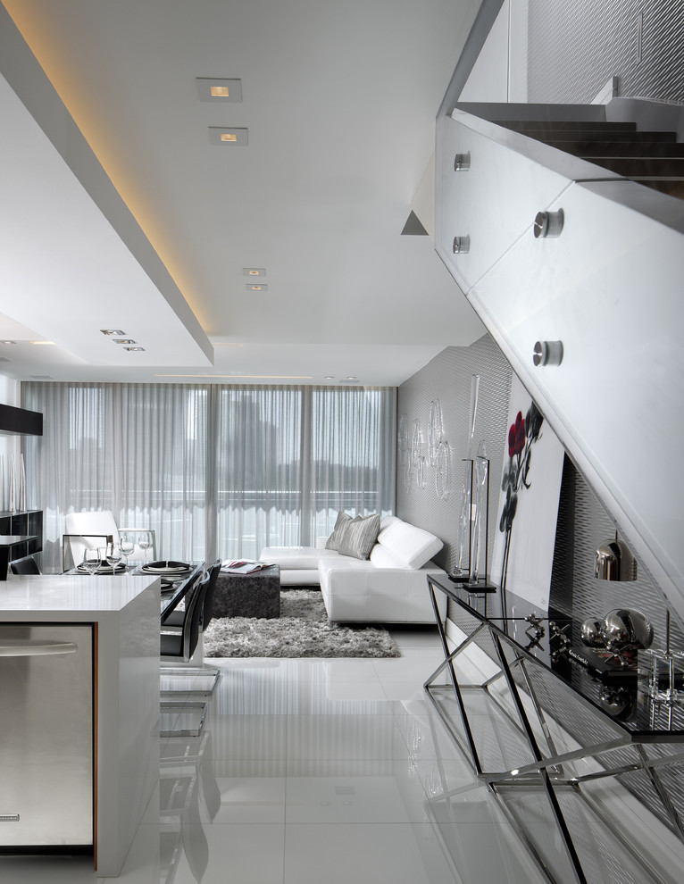 Idée de décoration pour un salon design de taille moyenne et ouvert avec un mur gris, une salle de réception, un sol blanc et un escalier.