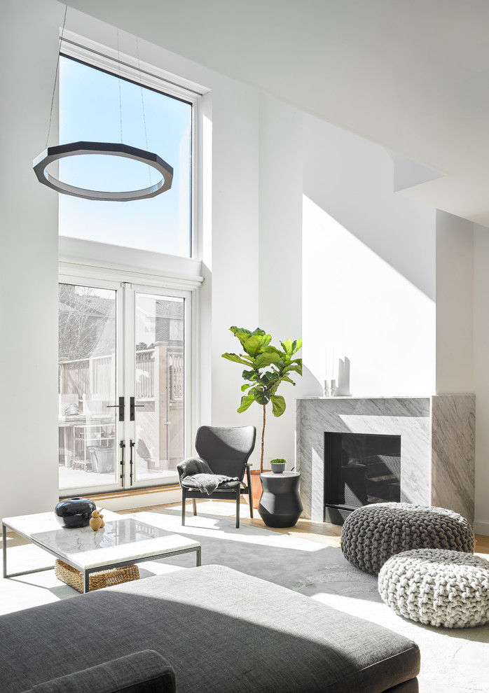 トロントにある高級な広いコンテンポラリースタイルのおしゃれなLDK (白い壁、無垢フローリング、標準型暖炉、石材の暖炉まわり、茶色い床) の写真