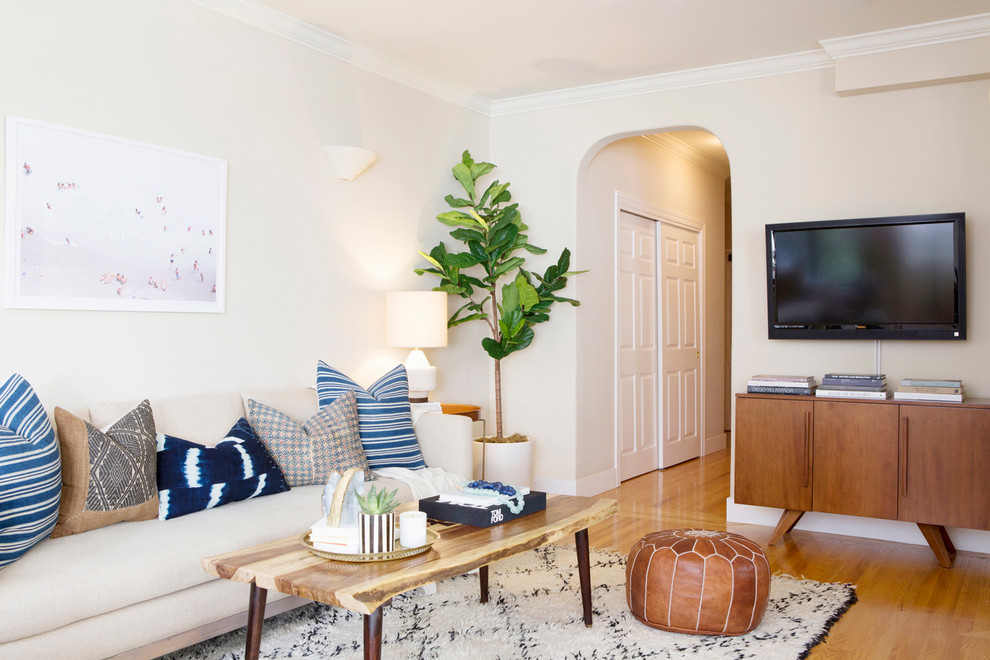 Klassisches Wohnzimmer mit beiger Wandfarbe, braunem Holzboden, TV-Wand und braunem Boden in San Francisco