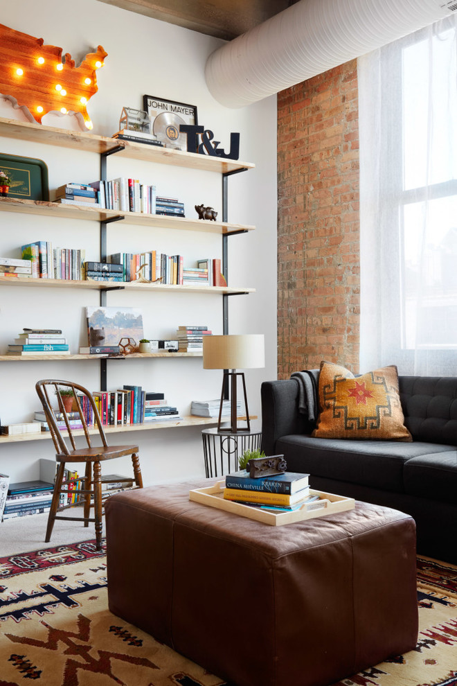 Immagine di un grande soggiorno stile loft con libreria, pareti bianche, moquette e nessuna TV