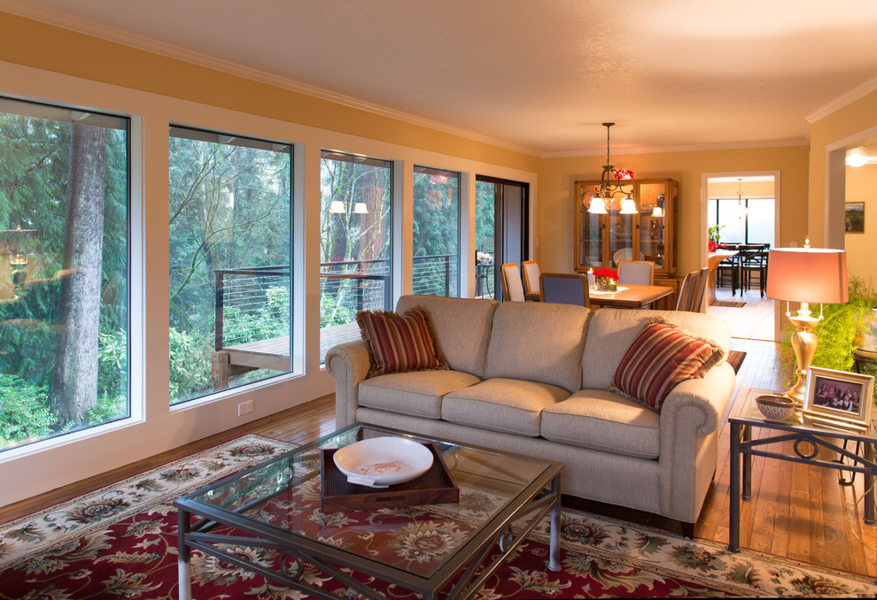 Esempio di un soggiorno design di medie dimensioni con pareti gialle, pavimento in legno massello medio e camino classico