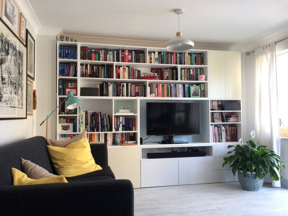 На фото: маленькая открытая гостиная комната в современном стиле с разноцветными стенами, полом из ламината, отдельно стоящим телевизором и серым полом для на участке и в саду