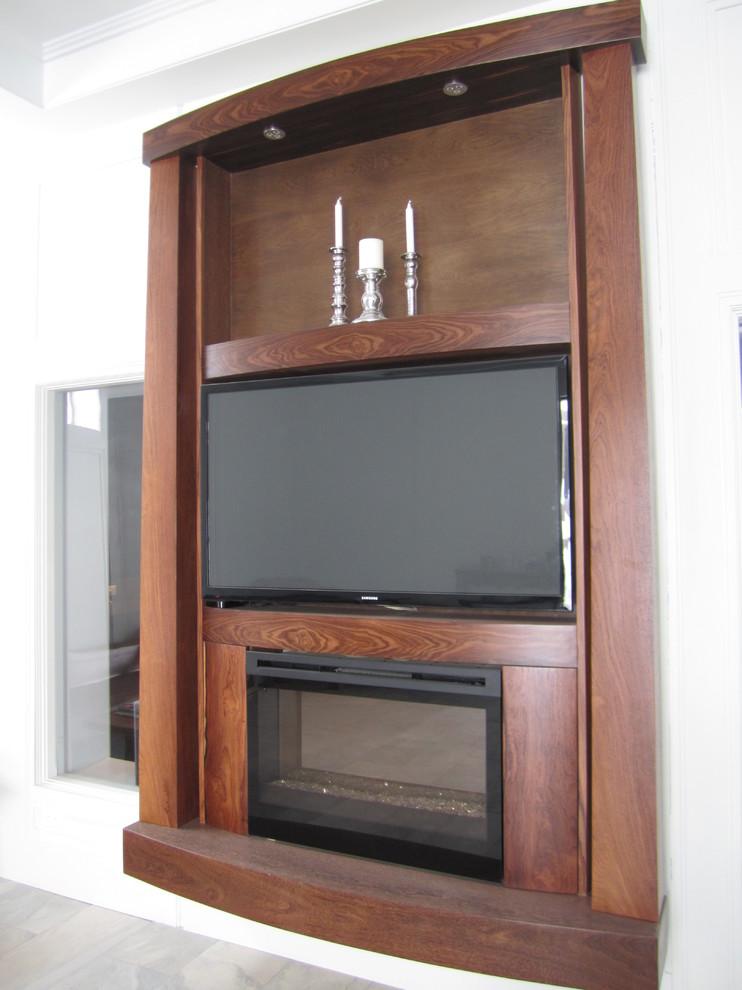 Cette image montre un très grand salon design ouvert avec un mur gris, une cheminée standard, un manteau de cheminée en bois et un téléviseur encastré.