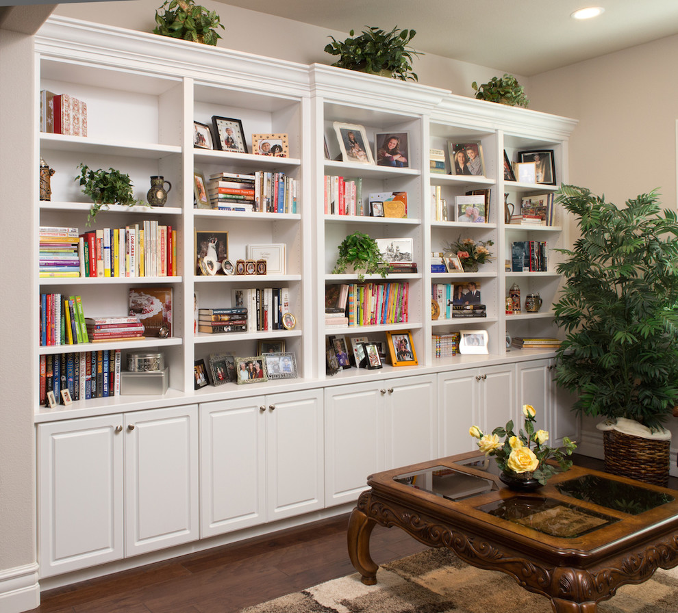 Diseño de biblioteca en casa cerrada minimalista de tamaño medio sin chimenea y televisor con paredes beige y suelo de madera en tonos medios
