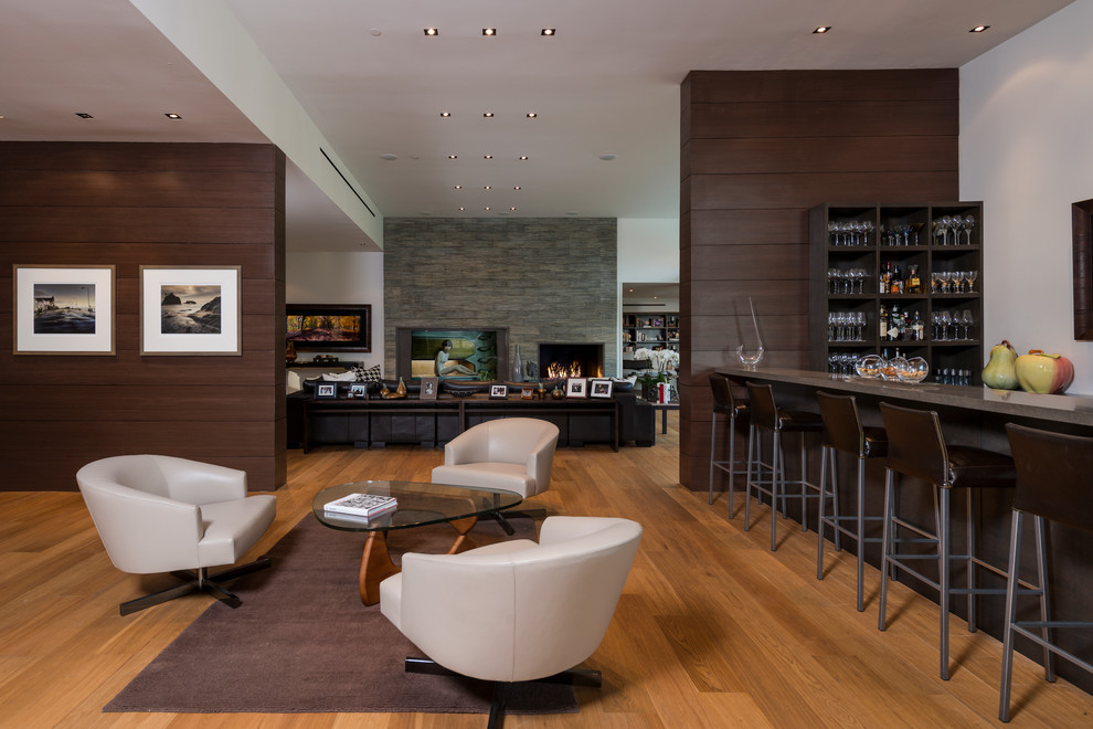 Inspiration for an expansive modern galley wet bar in Los Angeles with light hardwood flooring, beige floors, grey worktops and feature lighting.
